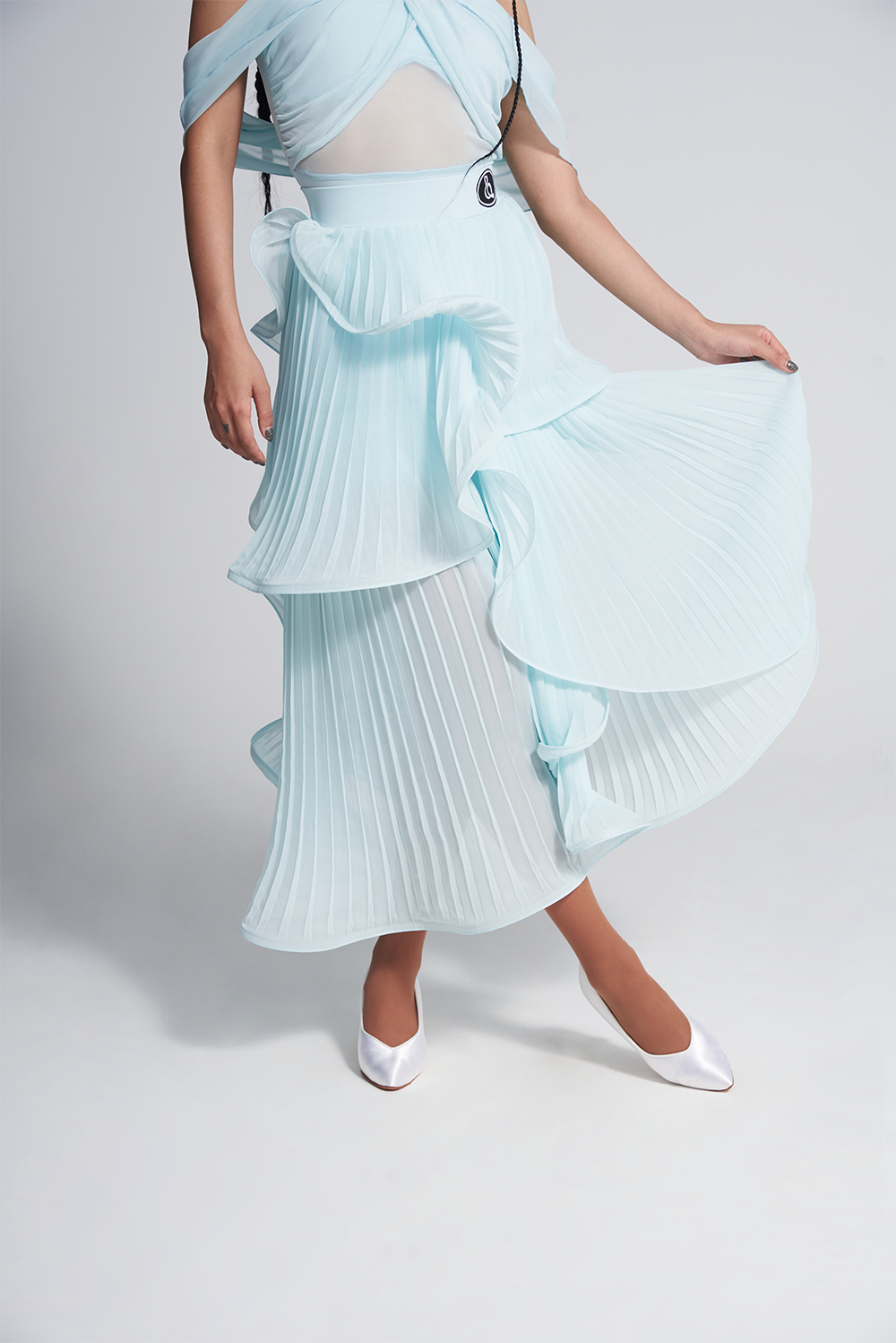 Enhance your performance with the DANCE QUEEN 493-2 Glacier Blue Pleated Ruffle Ballroom Skirt. This elegant and flowy skirt features pleated ruffles that create beautiful movement while dancing, helping you stand out on the dance floor. Made with quality fabric and precise stitching for a comfortable and professional fit.